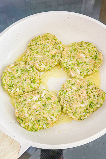 uncooked zuchini cakes in a skillet