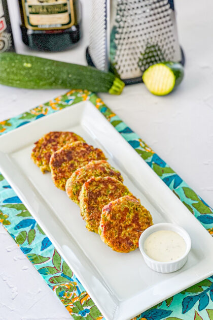 zucchini cakes on a platter with ranch dressing