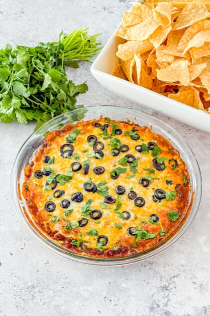 friendship dip made with cream cheese, canned chili, green chiles, shredded cheese, and olives