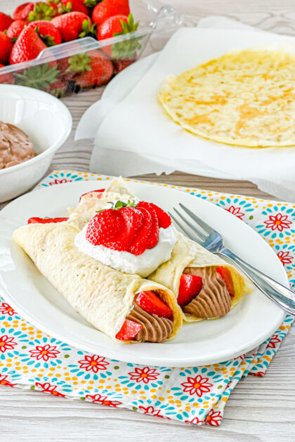 mouse filled crpes with strawberries and whipped cream