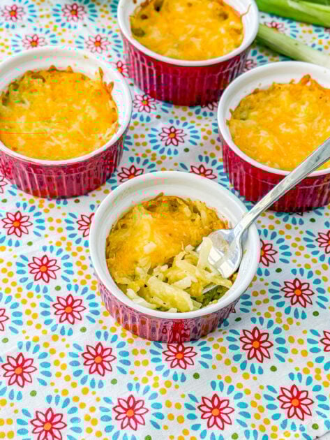 forkful of cheesy shredded potatoes au gratin showing creamy texture and melted cheese