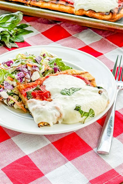 Slice of grilled Margherita pizza with fresh basil