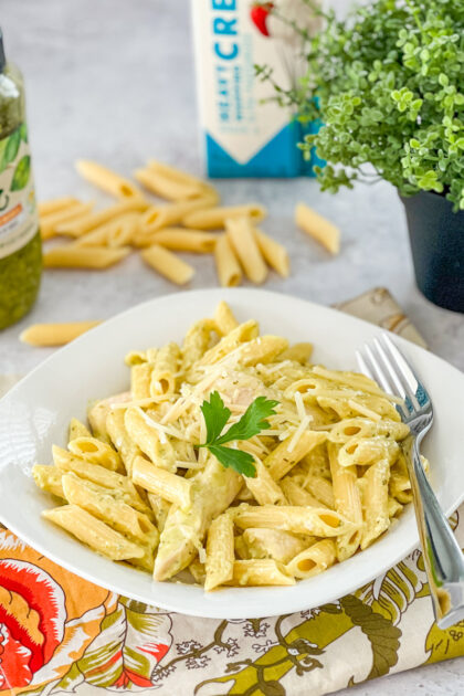 penne with chicken and pesto served in a white bowl