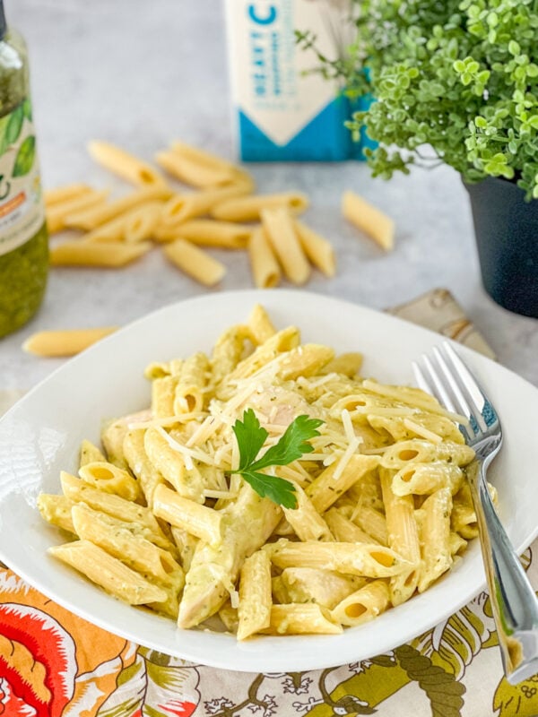 penne with chicken and pesto served in a white bowl