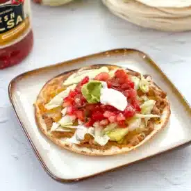 homamde cahlupas topped with lettuce, salsa, and sour cream