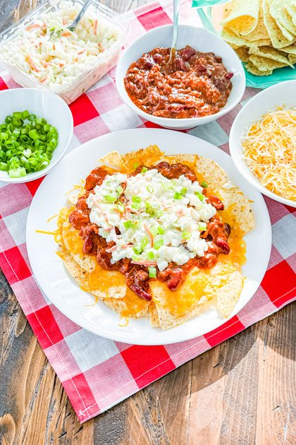 Corn tortilla chips topped with pulled pork, chili beans, and melted cheese