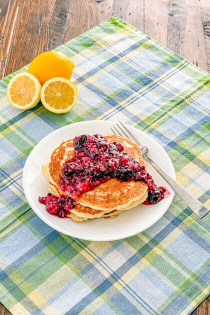 Overhead view of lemon ricotta pancakes with blackberry sauce