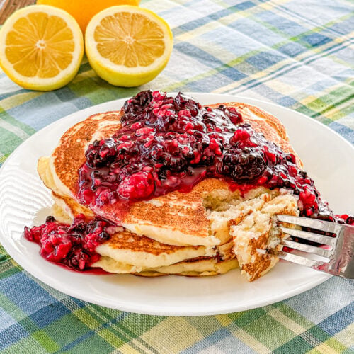 Lemon ricotta pancakes with blackberry sauce served as a summer breakfast