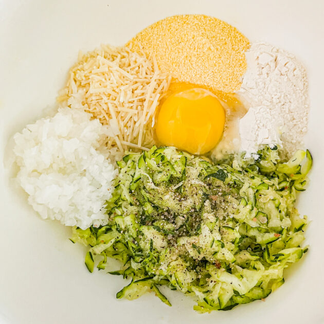 ingredients to Make zucchini fritters in a white bowl