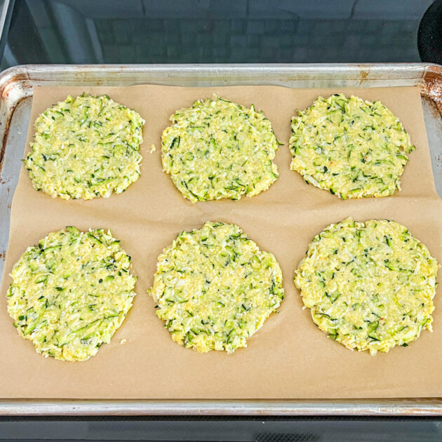 unbaked zucchini fritters on a baking sheet