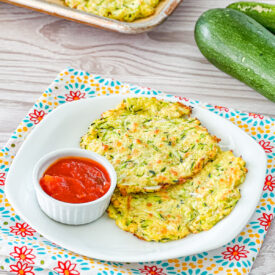Zucchinin fritters on a plate with marinara sauce