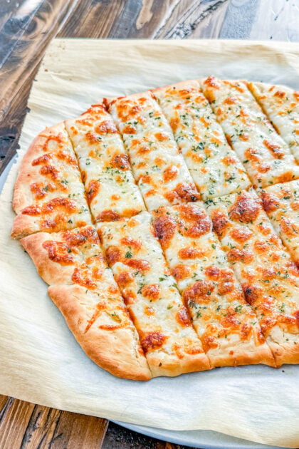 Golden garlic breadsticks topped with melted cheese and parsley