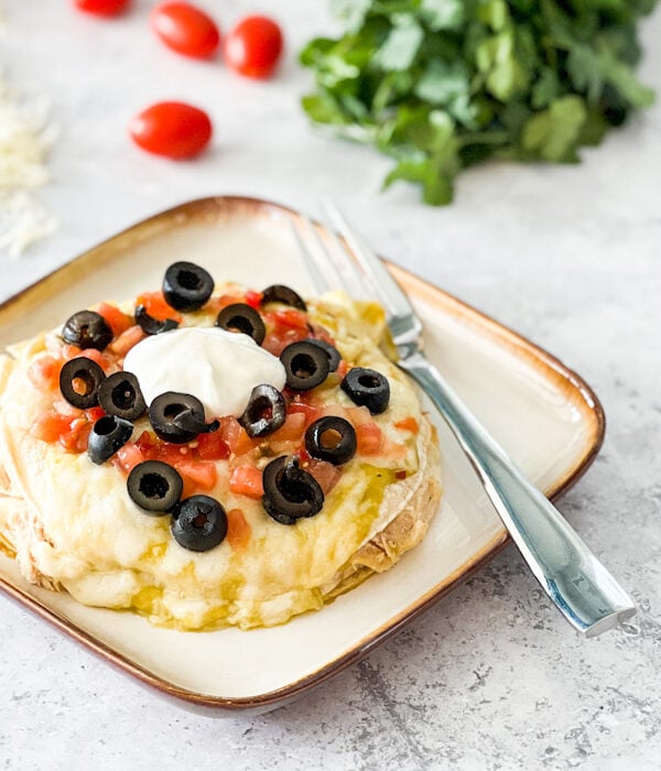 stacked enchiladas with green enchilada sauce