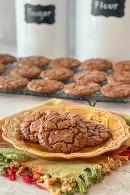 Fudgy Brownie Cookies on a yellow plate with more on cooling rack in background