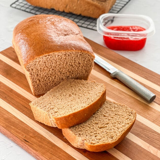 Slices of The Best Whole Wheat Bread on a wooden cutting board