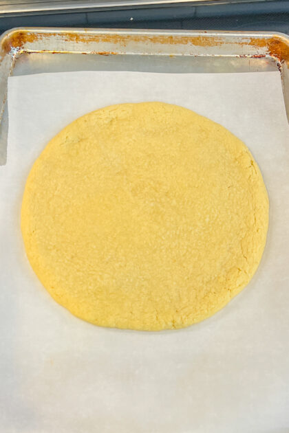Baked cookie on a baking sheet for a Giant Frosted Sugar Cookie