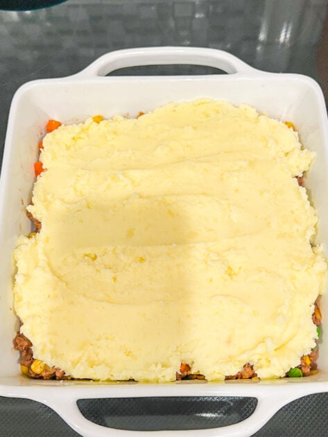 Mashed potatoes on top of the meat mixture for Ground Beef Cottage Pie