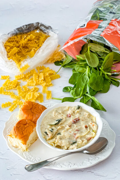 Bowl of white chicken lasagna soup with noodles and spinach