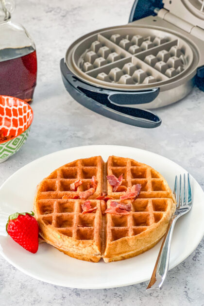 waffle sprinkled with bacon on a white plate
