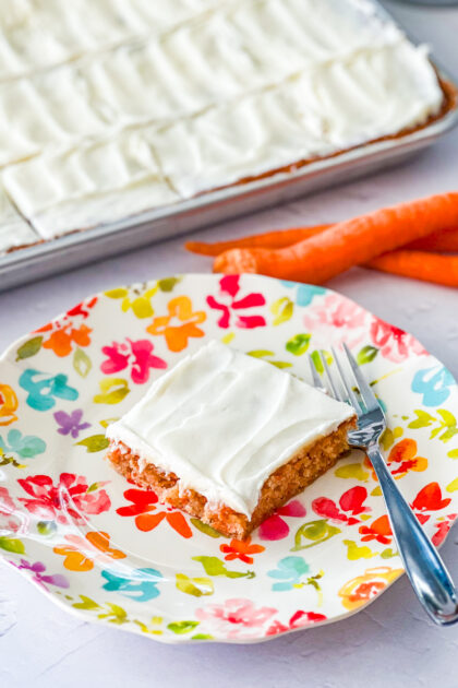 Carrot Cake Sheet Cake on a plate with carrots in the background