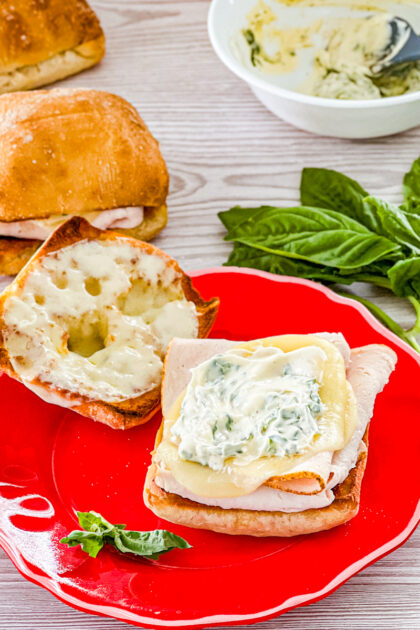 assembling turkey provolone sandwiches with basil mayo