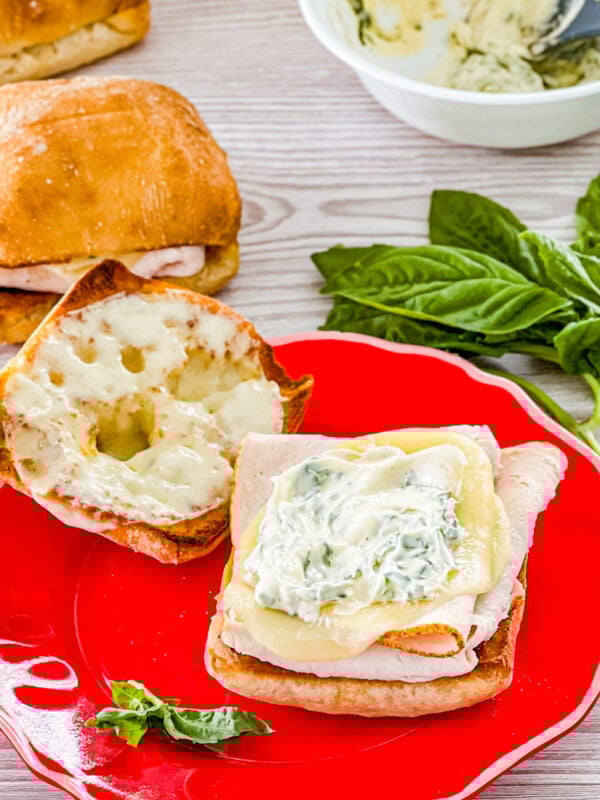 assembling turkey provolone sandwiches with basil mayo
