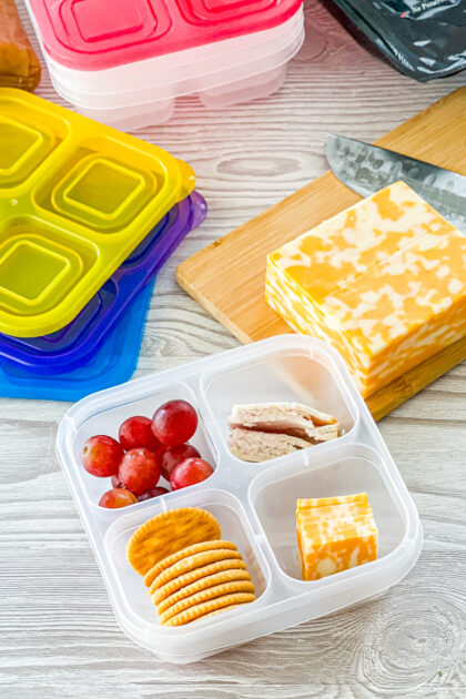 homemade lunchable with crackers, cheese, turkey, and grapes