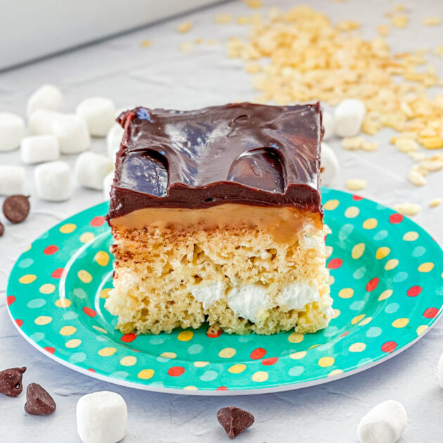 decadent rice krispie treats with a caramel layer and a dark chocolate ganche layer