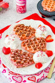 pink velvet waffles with nutella, strawberries, and whipped cream