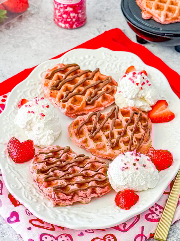pink velvet waffles with nutella, strawberries, and whipped cream