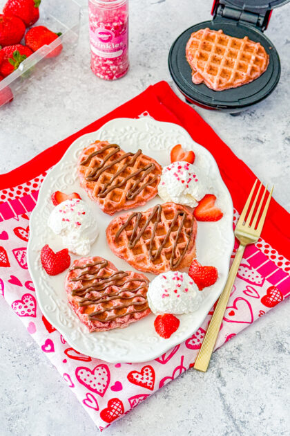 heart shaped pink velvet waffles make in a Dash waffle maker