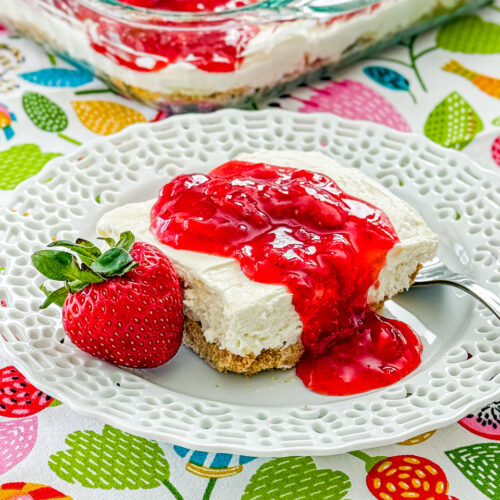 no bake strawberry cheesecake bars on white lacey plate
