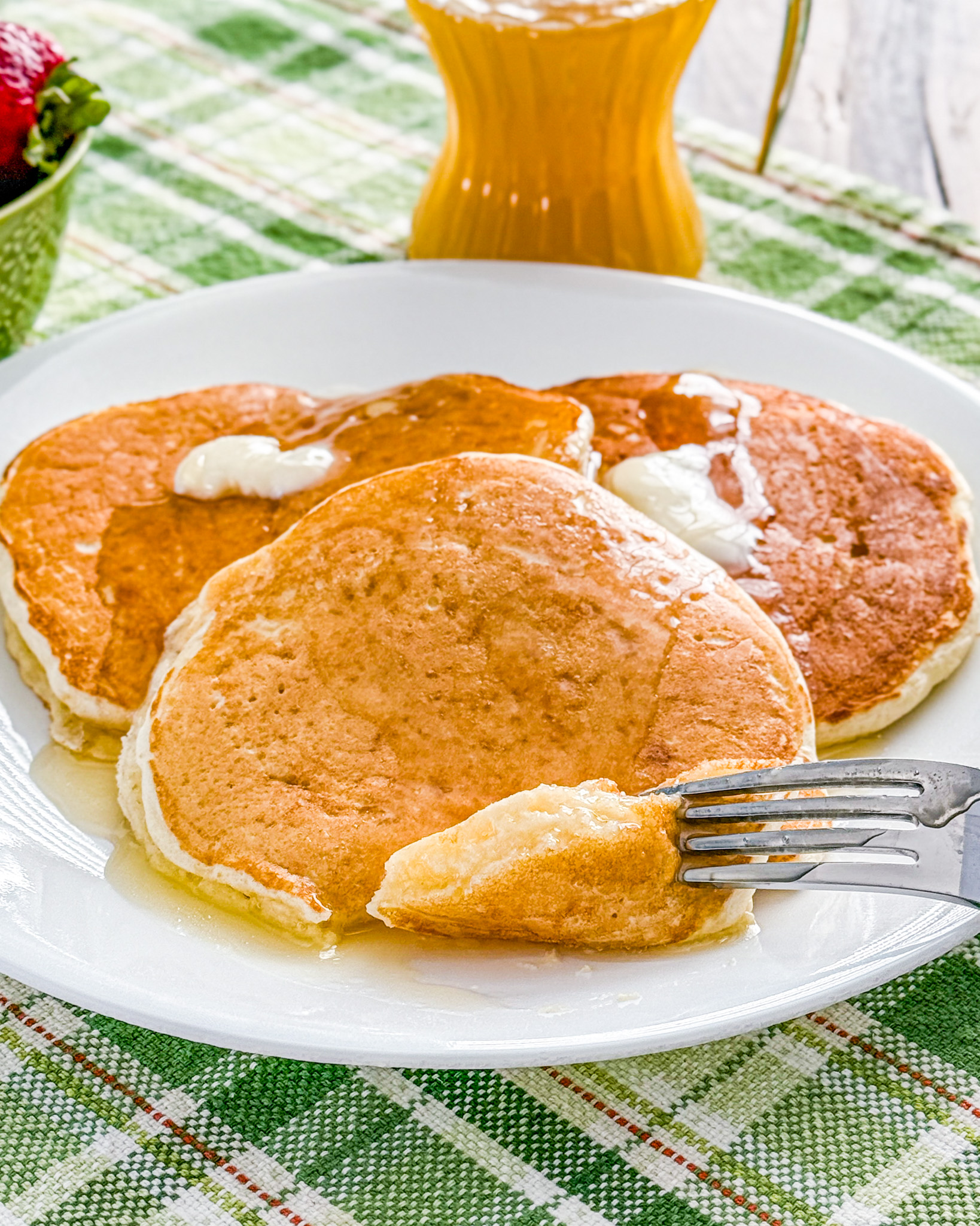 Fluffy pancakes made with sour cream substitute cooking on griddle