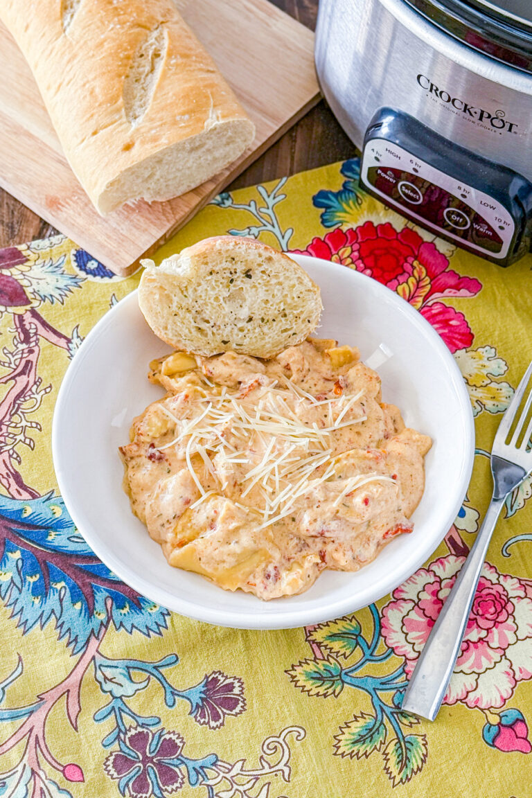 Slow Cooker Marry Me Chicken Tortellini in a bowl with bread by it