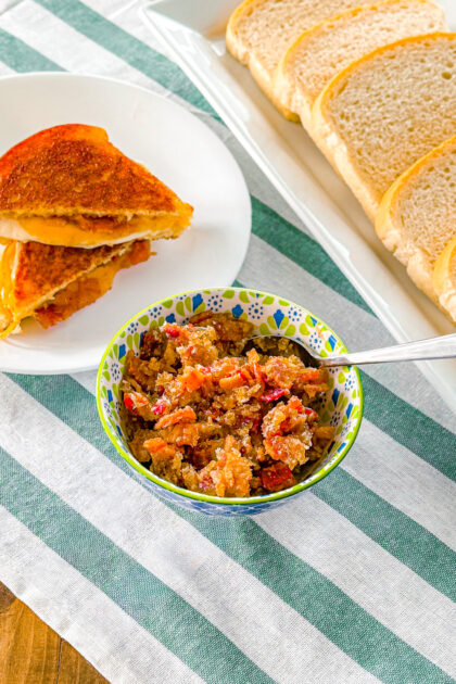 bacon jam in a bowl next to a grilled cheese sandwich