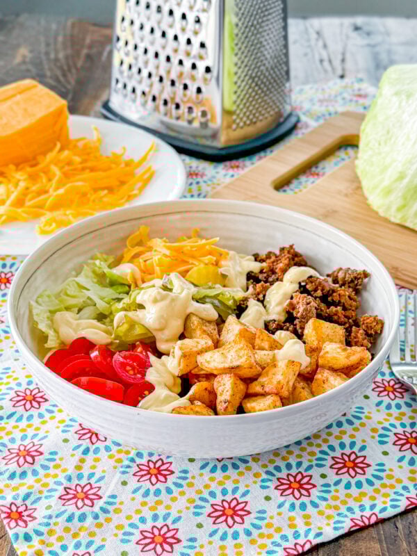 Loaded cheeseburger bowl with roasted potatoes, ground beef, cheese, lettuce, and special sauce.