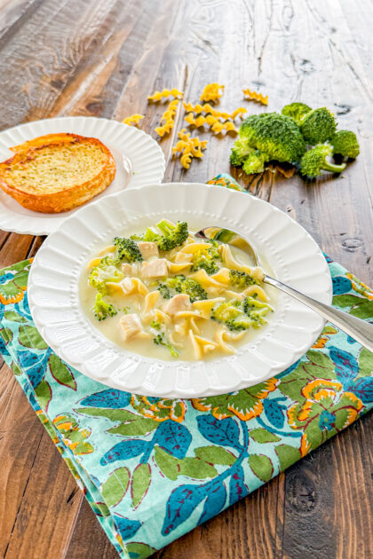 bowl of creamy chicken alfredo soup on a dark wood background