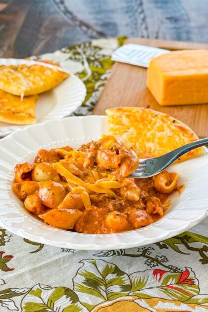 Bowl of homemade cheesy Italian shells with melted cheese and pasta shells