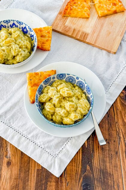 Overhead view of creamy pesto gnocchi in a creamy basil pesto sauce