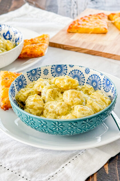 Close-up of creamy pesto gnocchi coated in a rich pesto cream sauce