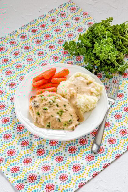 Overhead view of baked buttermilk chicken with gravy in a baking dish
