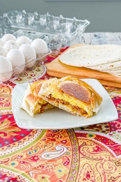 Cut open breakfast crunchwrap filled with scrambled eggs, bacon, melted cheese, and crispy hash browns