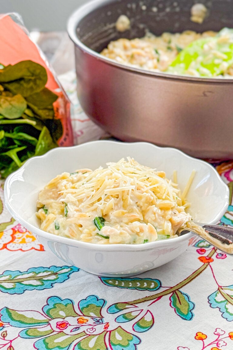 Close-up of creamy lemon chicken orzo with spinach and grated Parmesan