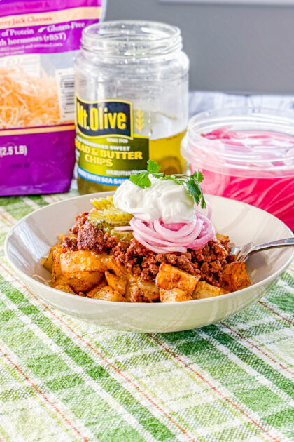 Loaded sloppy joe bowl topped with pickles, pickled onions, sour cream, and cilantro