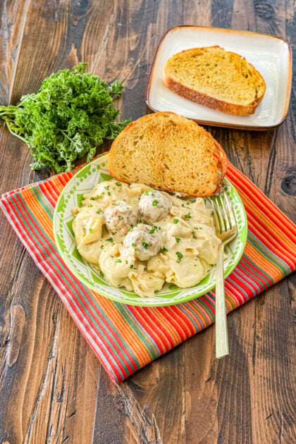 Overhead view of creamy meatballs with tortellini in the slow cooker