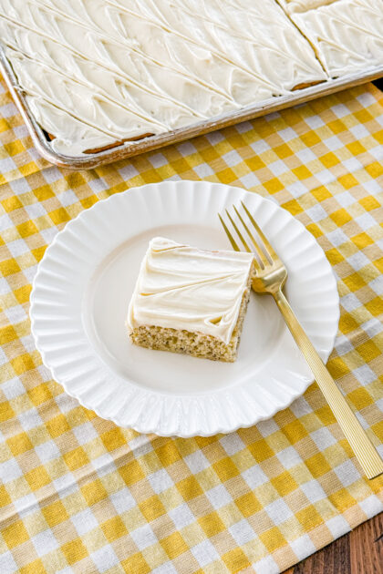 Square of banana bars with cream cheese frosting on a plate