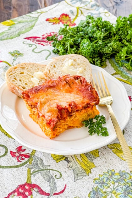 Friendship spaghetti pie with spaghetti, meat sauce, ricotta, and mozzarella cheese served with slice of bread