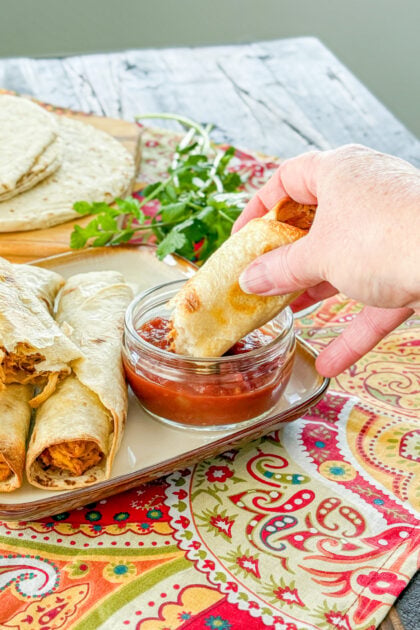 Baked chicken taquito dipped in salsa