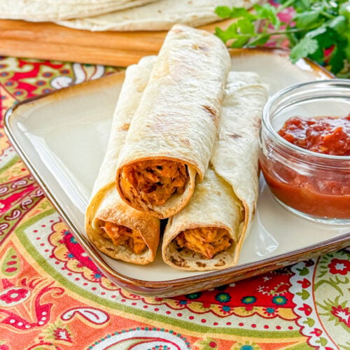 Slow cooker baked chicken taquitos with crispy tortillas and creamy chicken filling