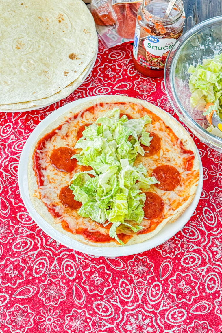 Pizza tortilla topped with Caesar salad before being rolled into a wrap